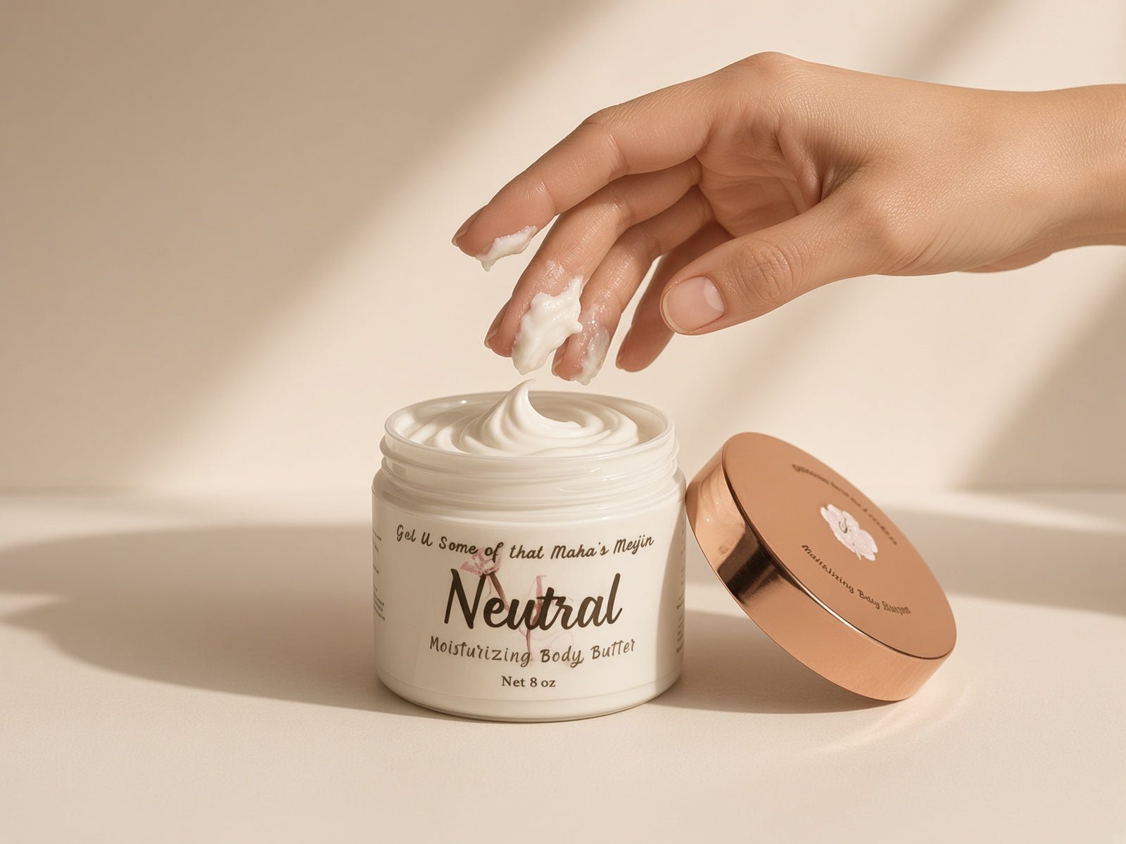Hand scooping whipped butter from an open jar of Neutral Body Butter